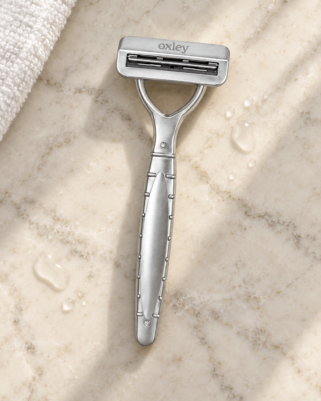 Oxley razor on a marble bathroom counter beside a folded towel